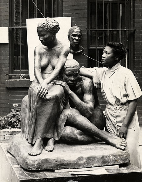Augusta Savage posing with her sculpture Realization